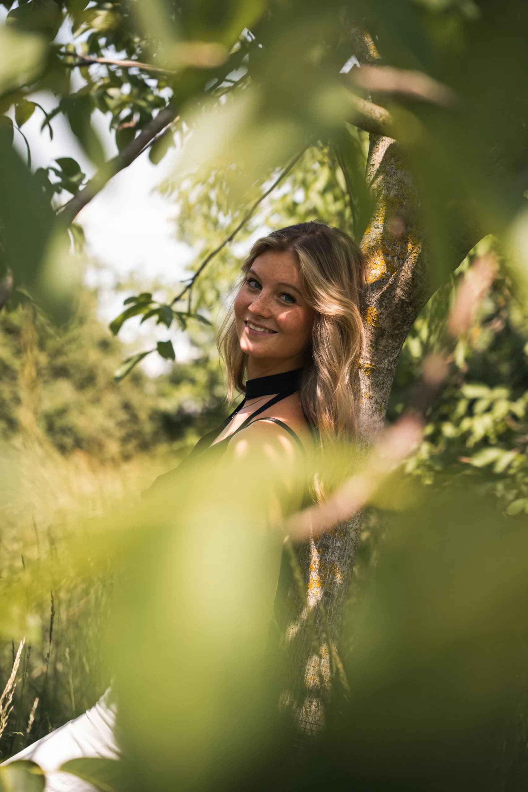 junge frau laechelnd im naturbaum